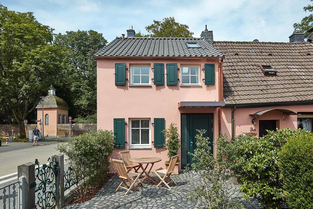 Gepflasterter Vorplatz mit Gartenmöbeln vor einem alten, sanierten kleinen Stadthaus in Düsseldorf Kalkum.