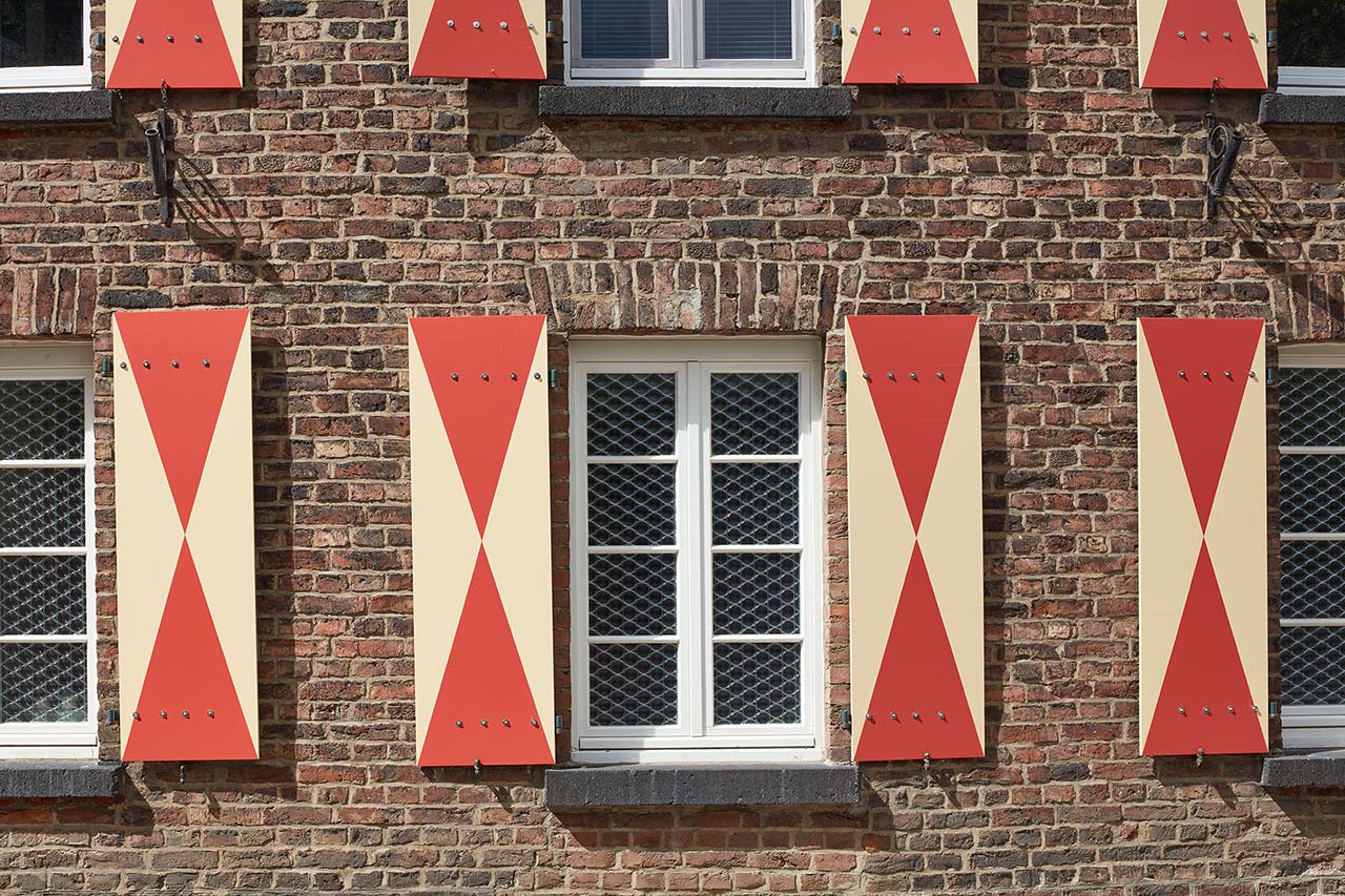 Holz-Fensterläden in Rot-Hellgelb.