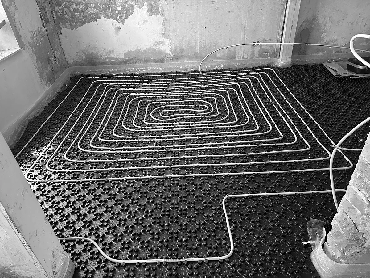Verlegte Fußbodenheizung während der Sanierung mit Heizschleifen auf Noppenplatte vor dem Estricheinbau.