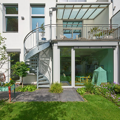 Gartenansicht mit Spindeltreppe zum Obergeschoss einer sanierten Maisonettewohnung